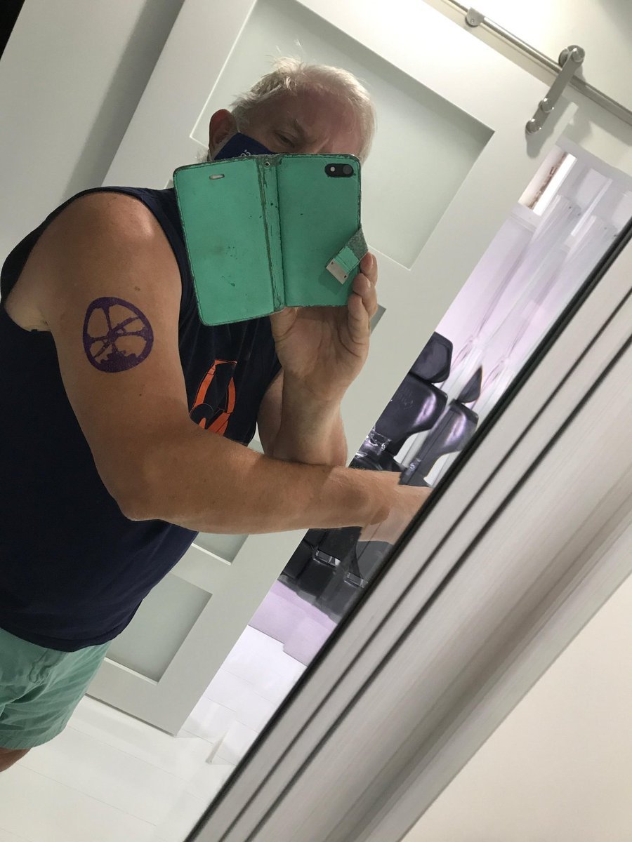 A man's upper arm with a freshly inked Roam logo, mirror selfie.